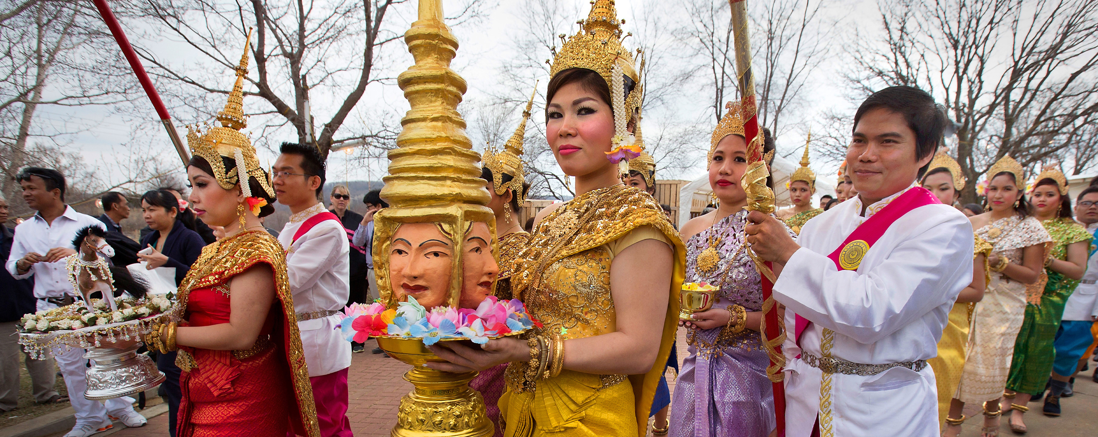 A woman dressed in gold is part of a procession during during Khmer New Year celebration in Southeast Asia.