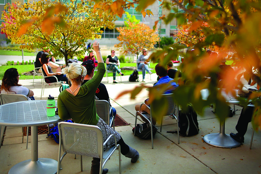 A class is held outside amidst fall leaves.