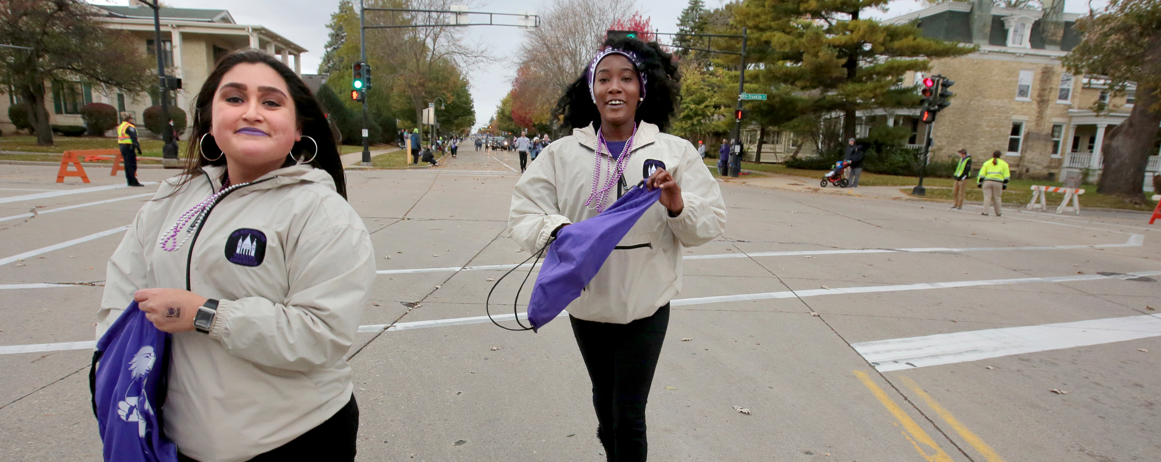 Two students participate in community events as they walk down the street.
