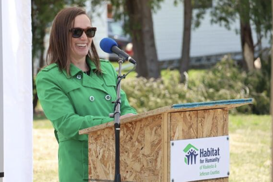 Rebecca Houseman laughs at a podium.