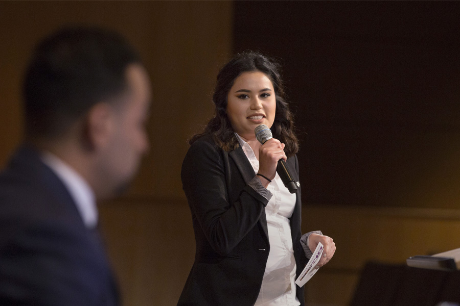 A young woman speaks into a microphone.