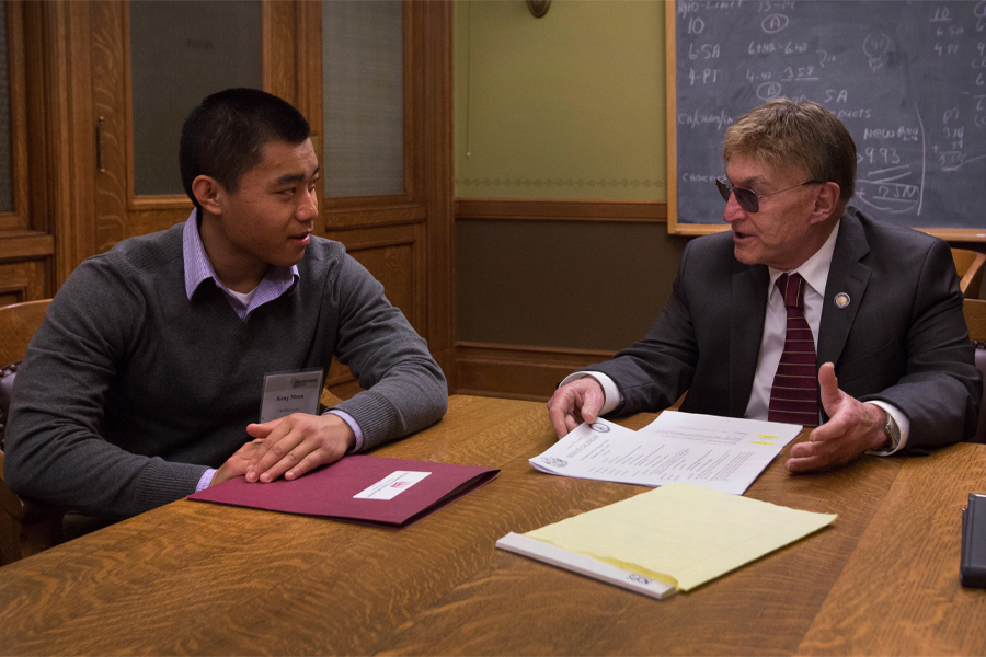 Two people talk around a table.