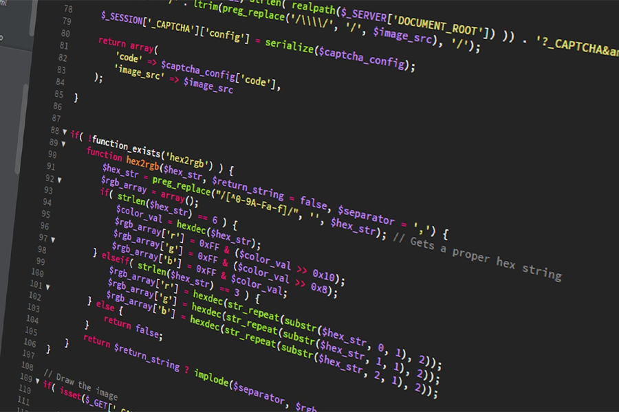 A computer monitor shows lines of colorful coding.