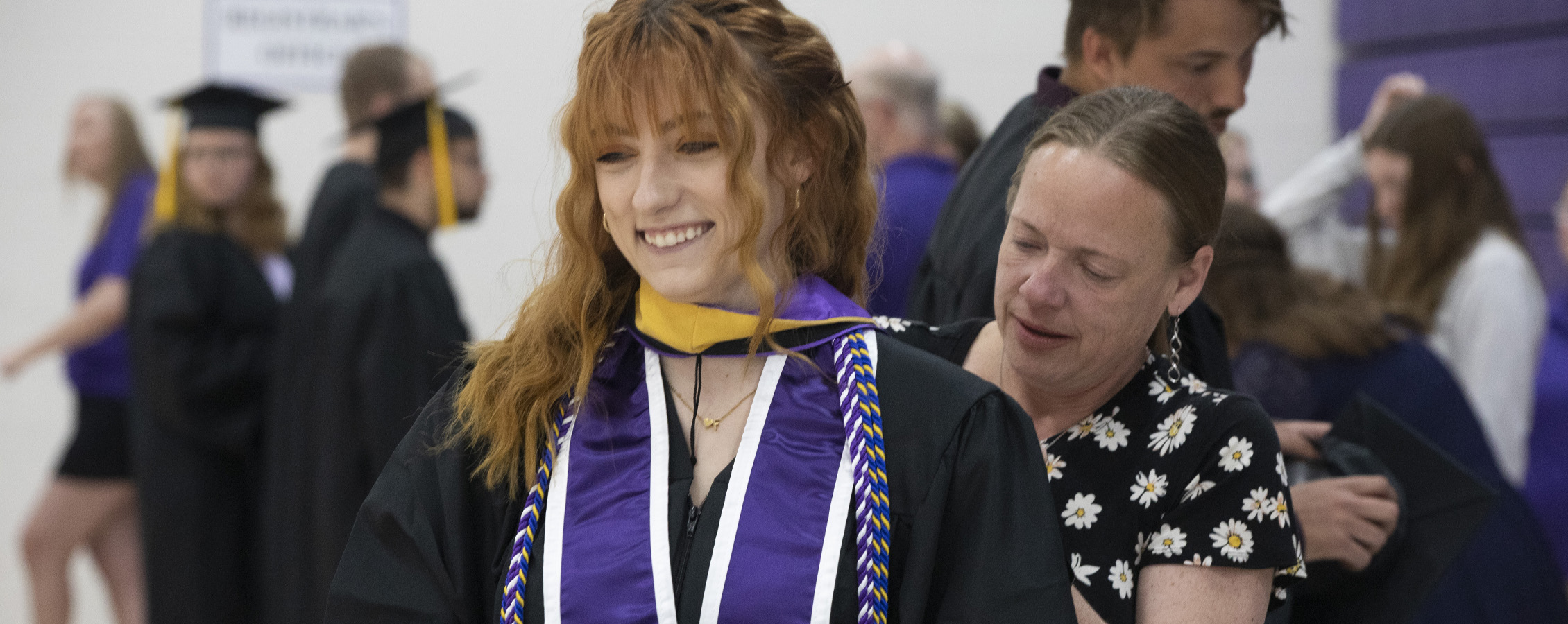 A social work student smiles at Commencement.