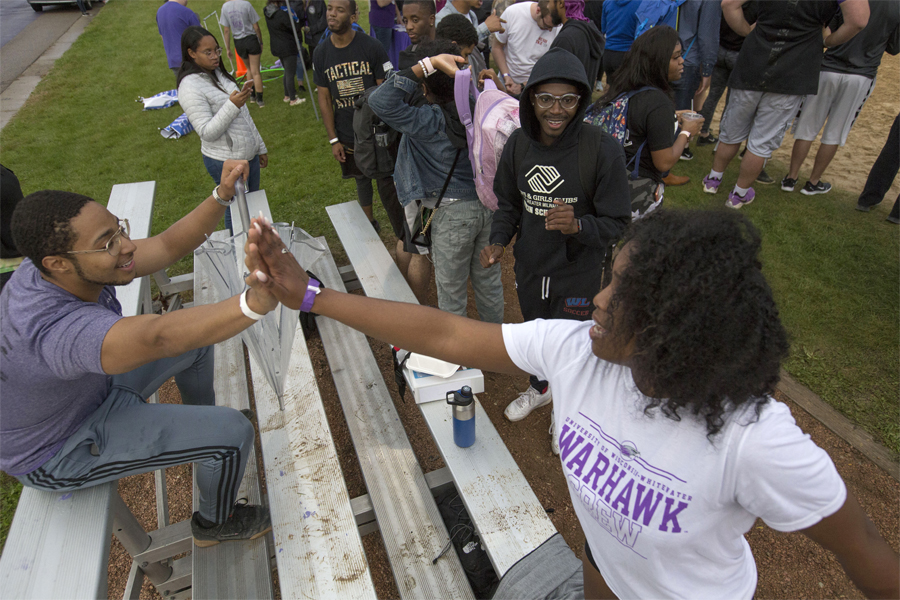 Two students high five.