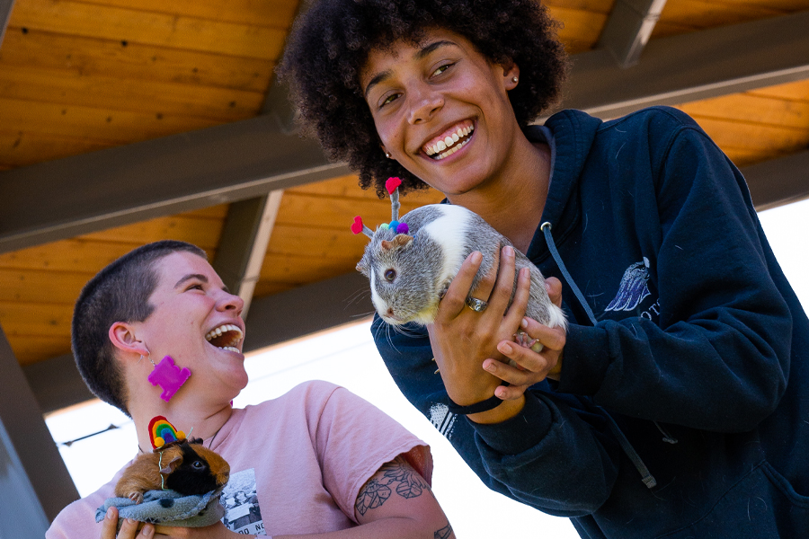 Two students hold guinea pigs.