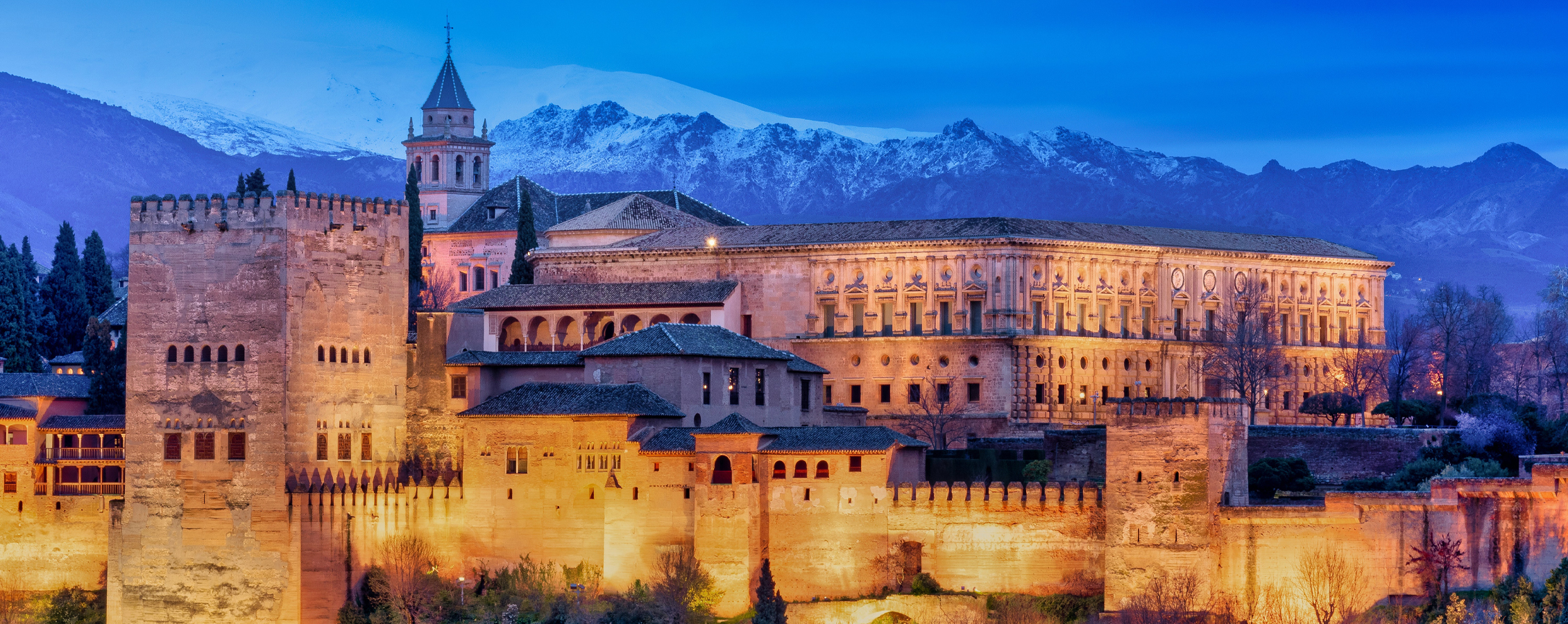 Castle Alhambra with mountains in the background.