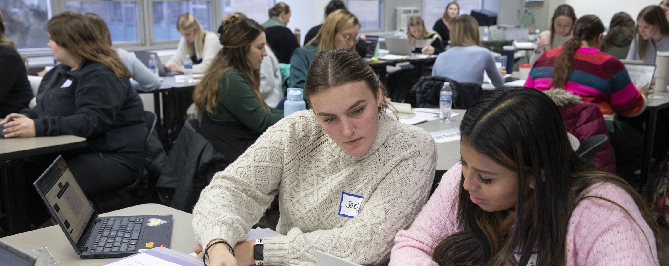 Two students work together in a classroom.
