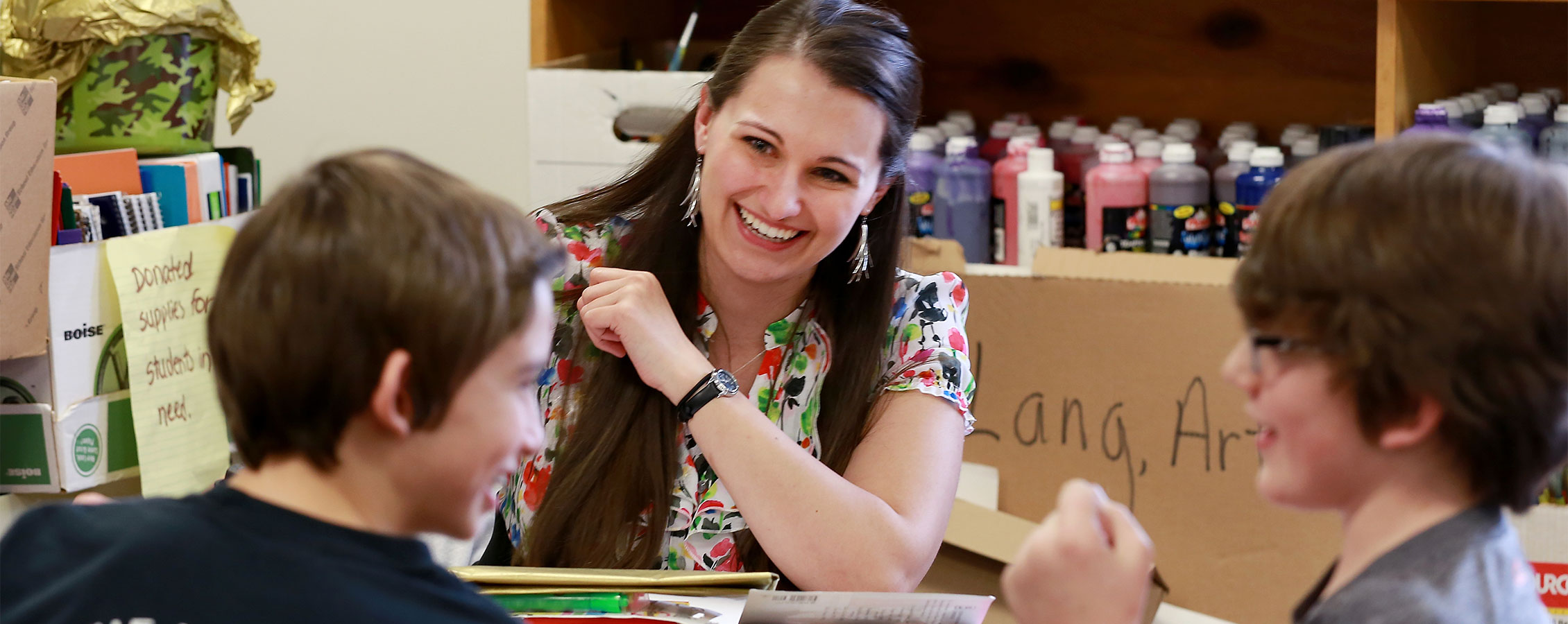 Elementary school teacher laughs with students