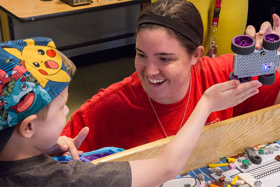 Early childhood teacher helping student in class