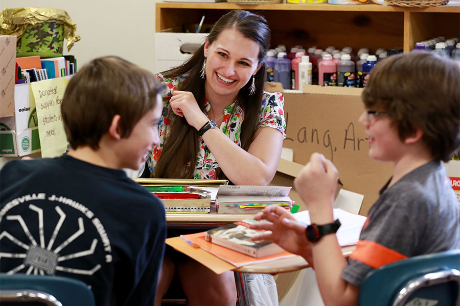 A teacher works with two young students.