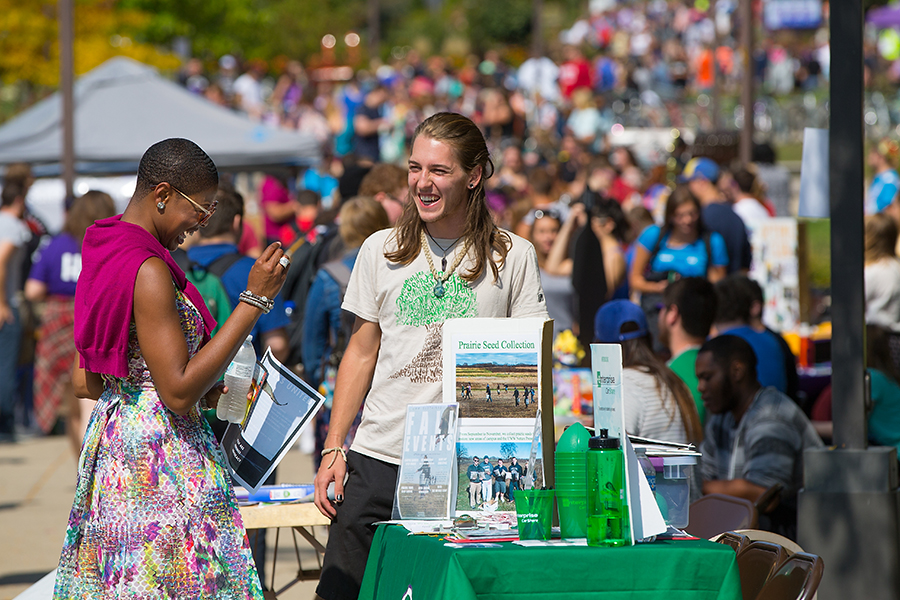 A member of the chancellor's cabinet shares a laugh with a student.