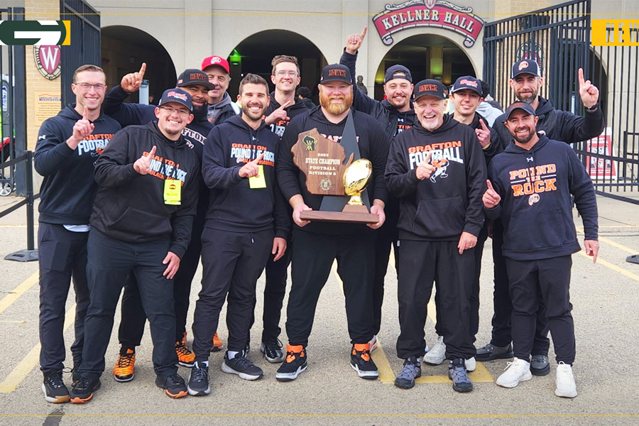 Jim Norris holding a trophy surrounded by other coaches.