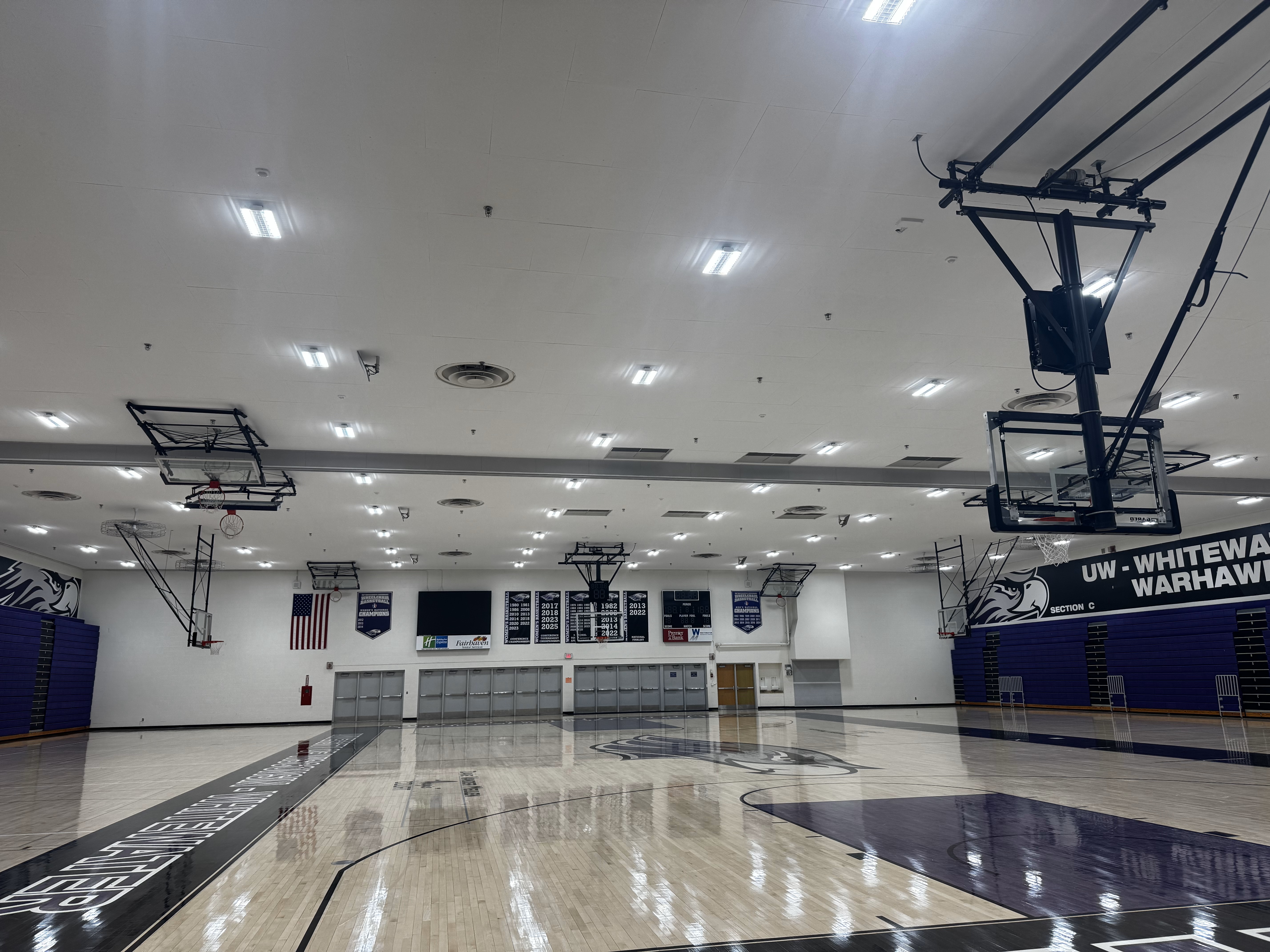 Photo of the Williams Center basketball court with a new ceiling and lights. The gym is bright with clean crisp light over the courts.