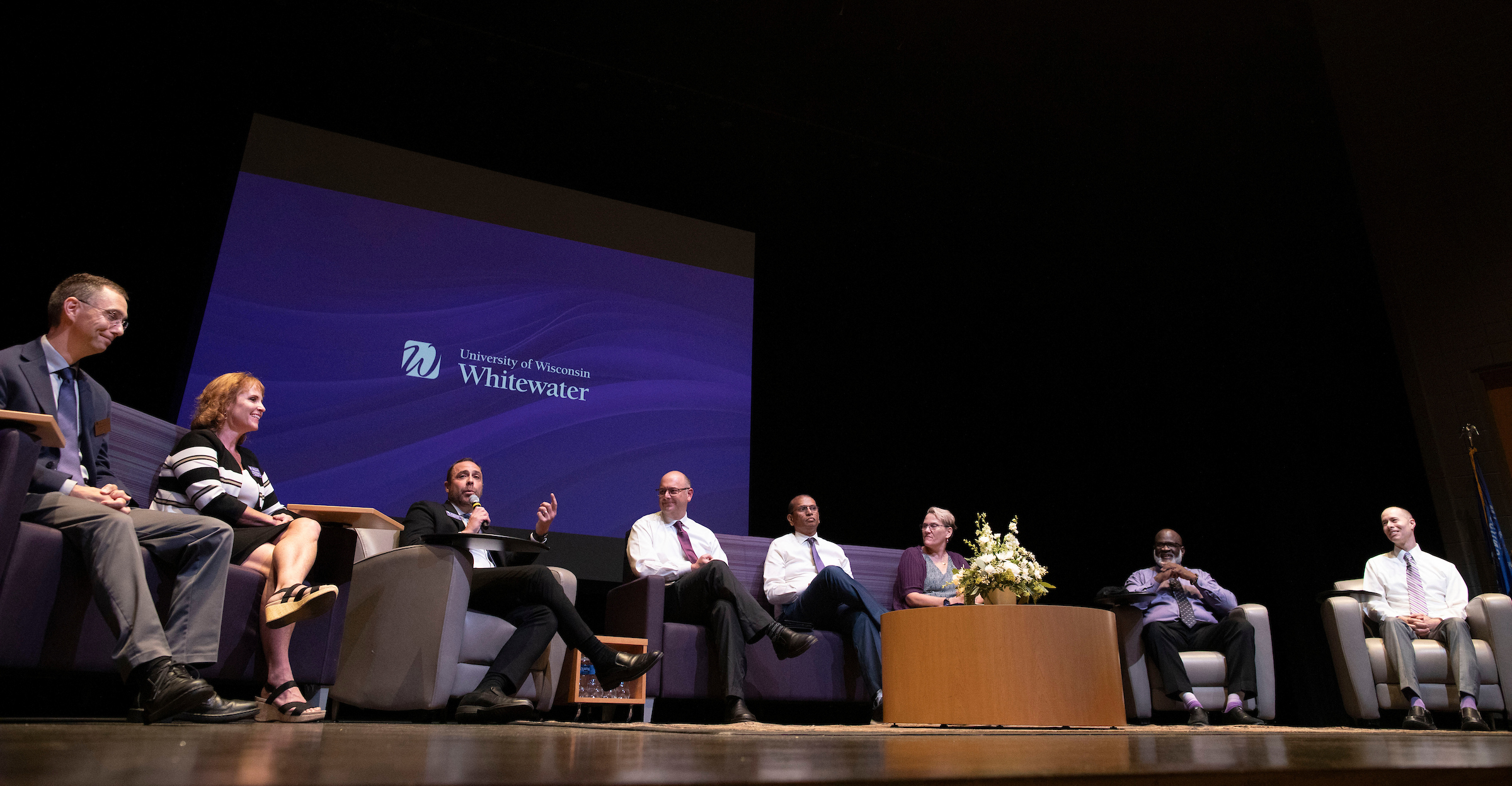 Jeff Angileri sits on a stage with a group of people.