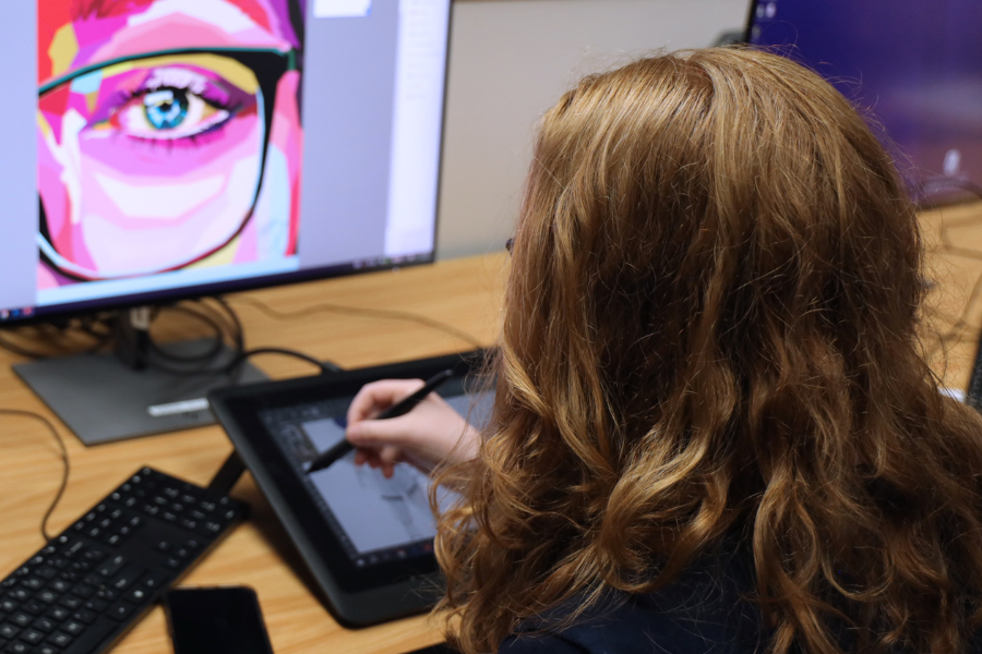 Student designs art using a laptop