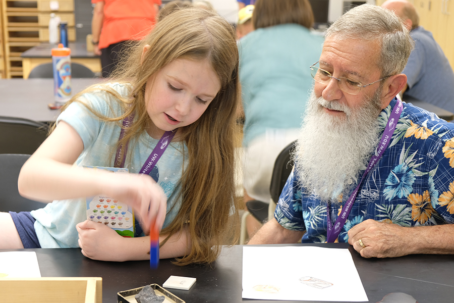 Grandparent helps his grandchild with a project