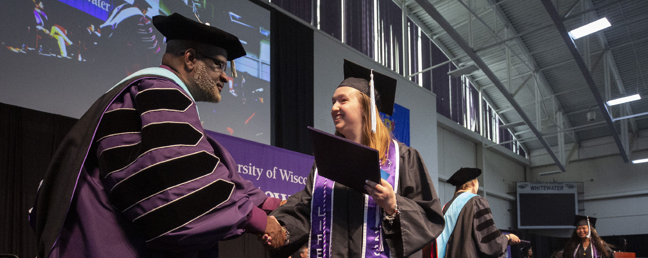 Chancellor King shakes a graduates hand as they cross the stage during commencement.