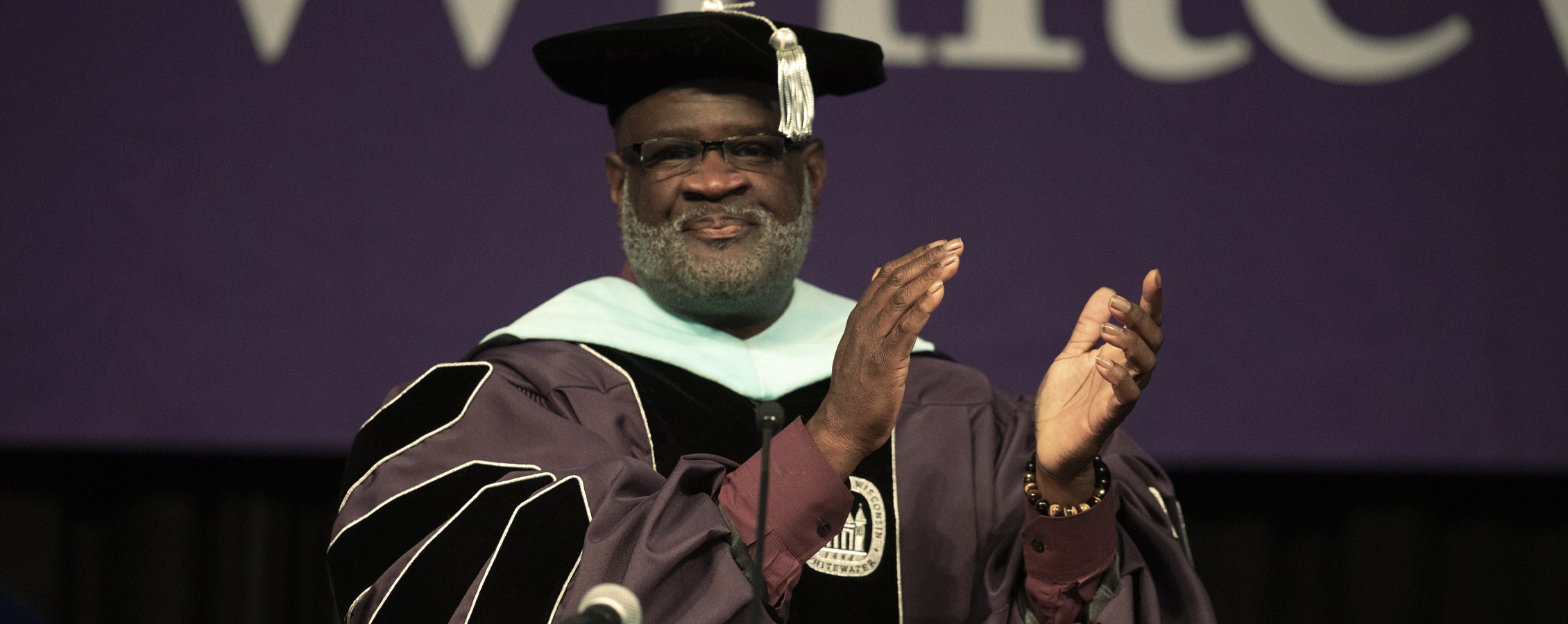 Chancellor King claps at graduation.