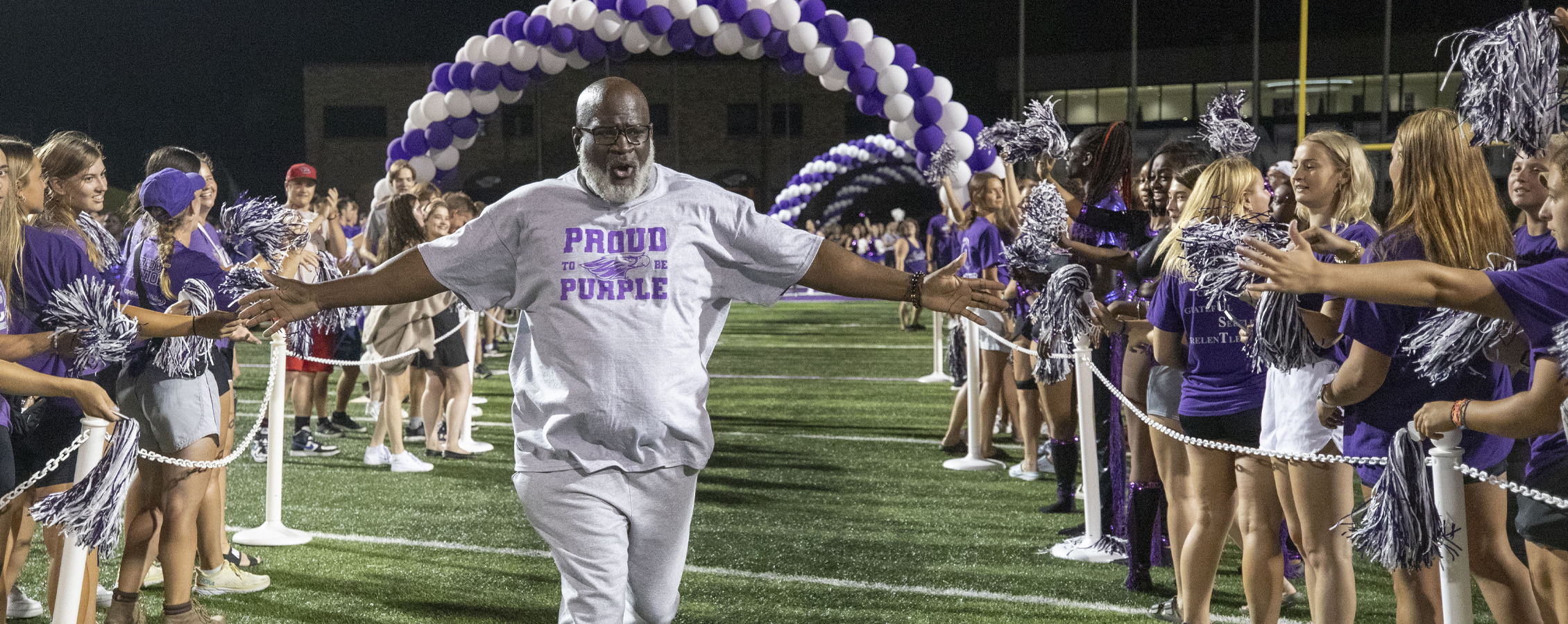 Chancellor King runs through the human tunnel at RU Purple.