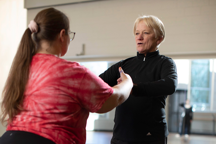 Barbara Grubel helps a dancer with her form in the dance studio