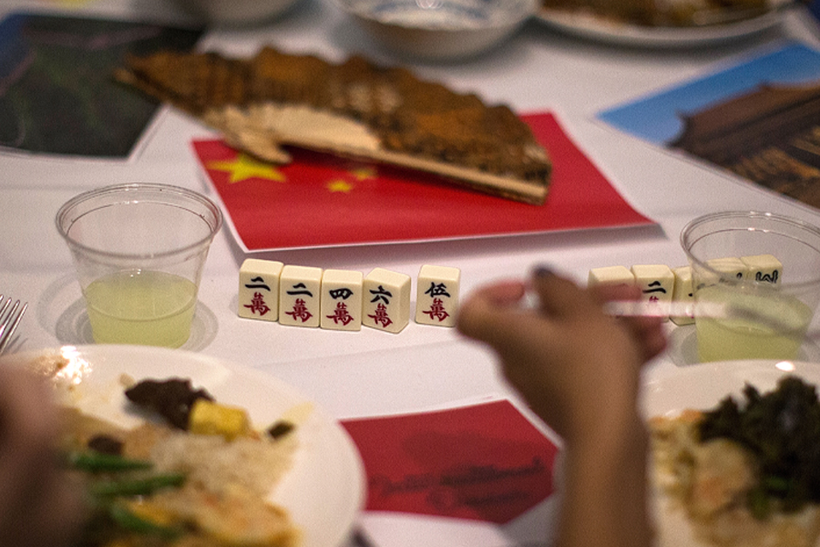 People eat a meal at a table with a small Chinese flag on the table.