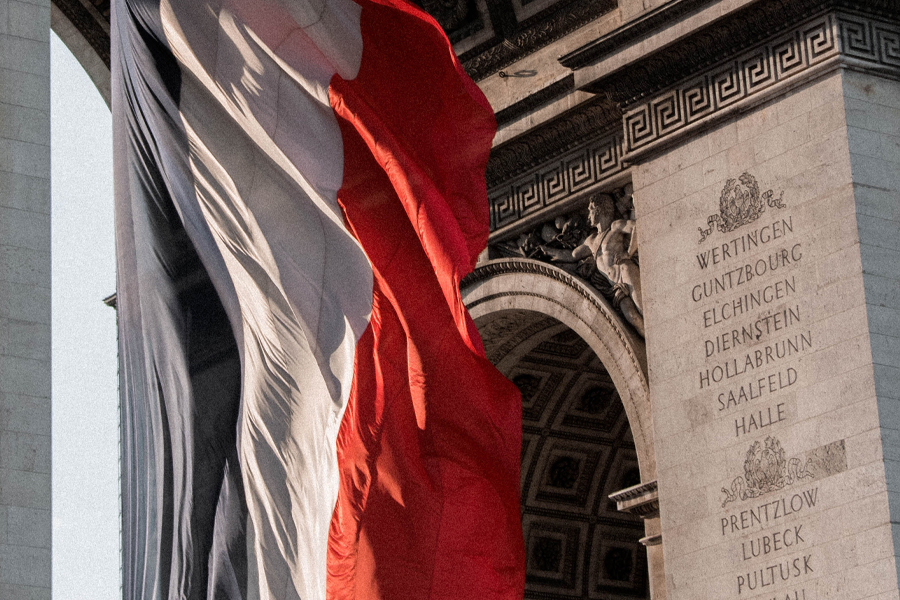 The French flag flies near the Arc de Triomphe.