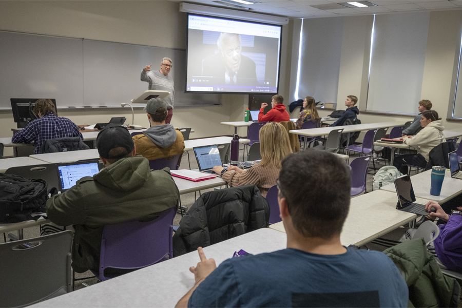 A faculty member talks in front of a class.