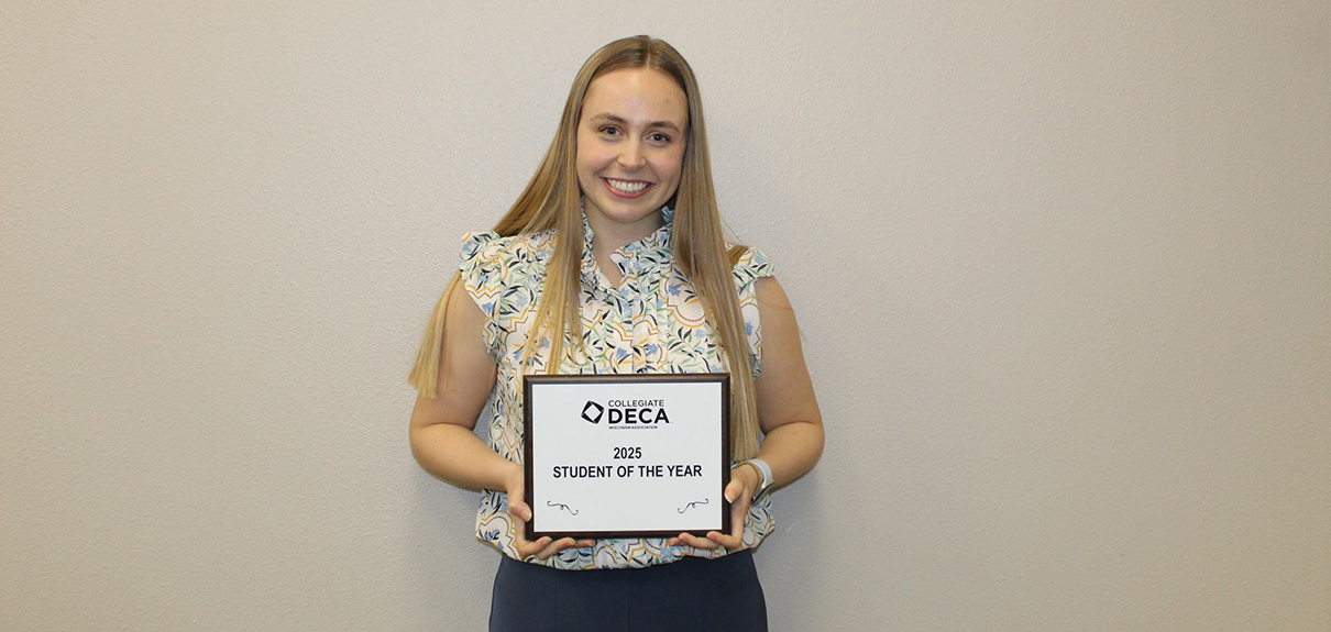 Bella Biever, a student at the University of Wisconsin-Whitewater, proudly holding the 2025 Student of the Year award