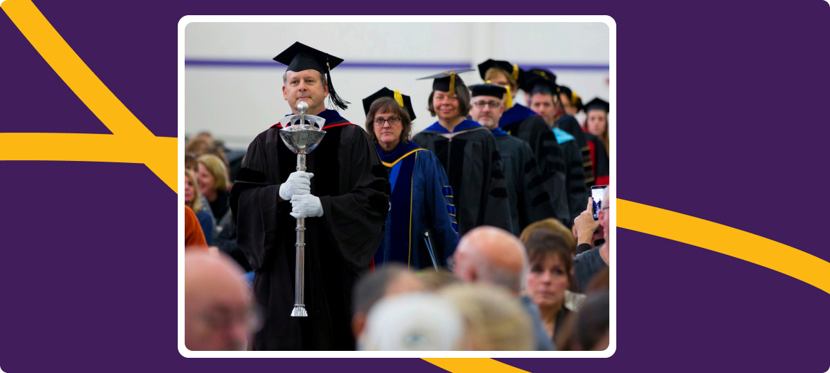Jimmy Peltier, left, carries the Mace during the processional of the 2016 winter commencement ceremony, an honor accorded to the W.P. Roseman Excellence in Teaching Award recipient.
