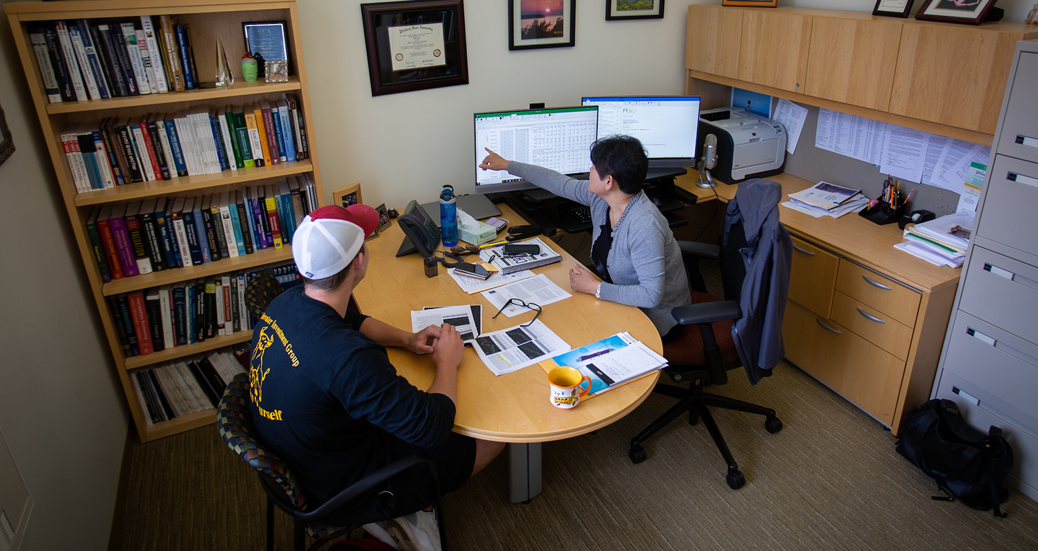 Linda Yu, department chair and professor of finance, meets with a student on campus at UW-Whitewater.