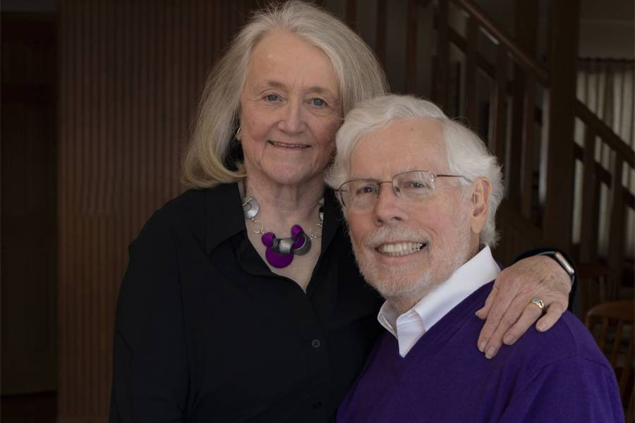 A portrait of the Telfers, with their arms around each other and smiling at the camera.