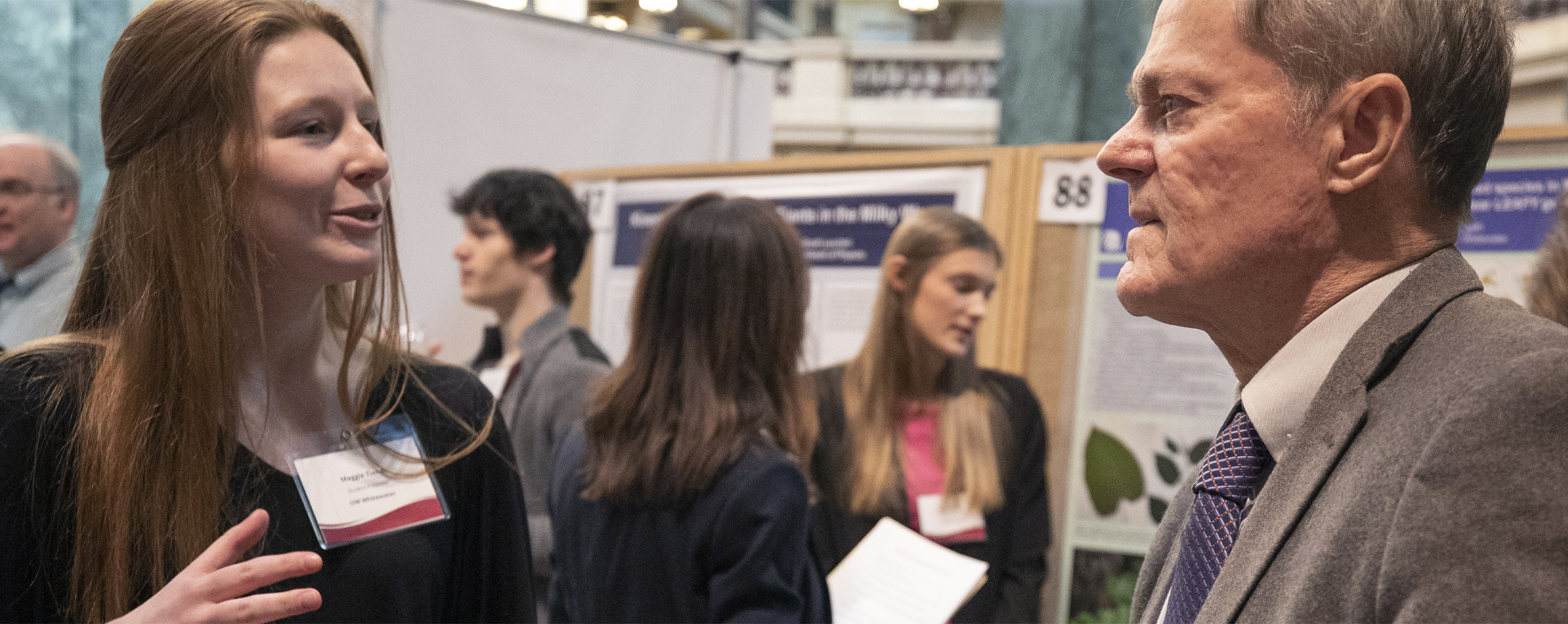 Two people talk at a conference.