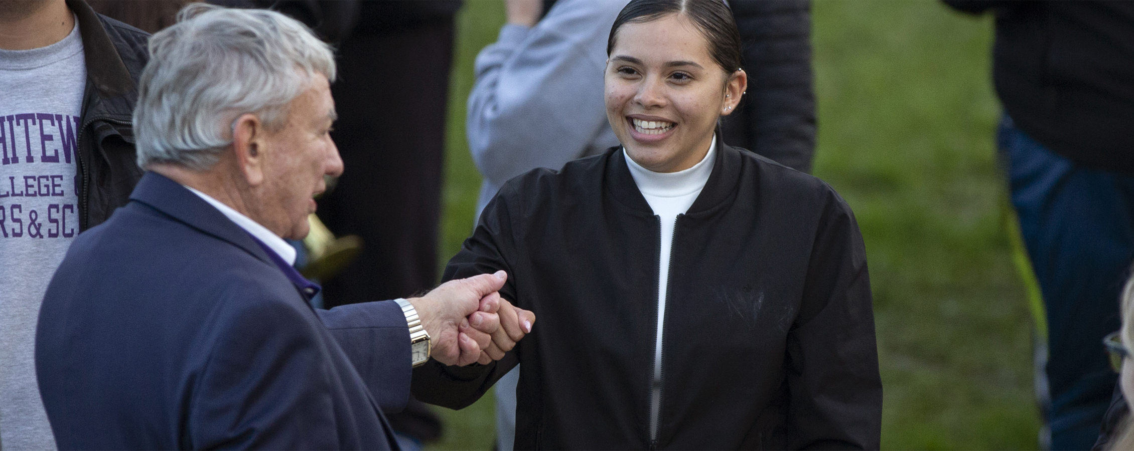 A student smiles and talks with former governor Tommy Thompson.