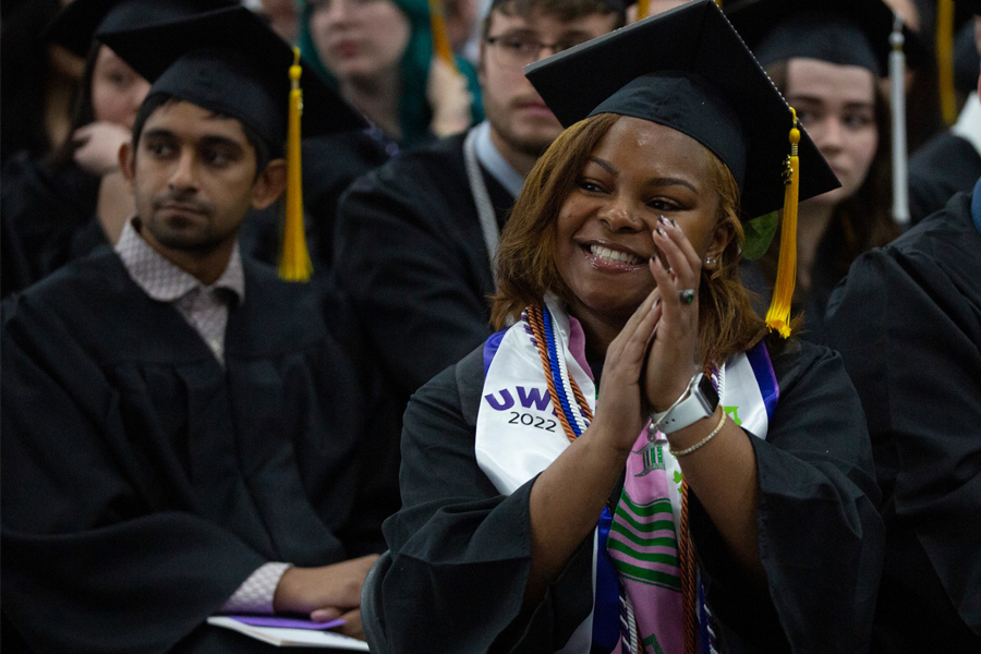Students clap in the crowd at commencement.