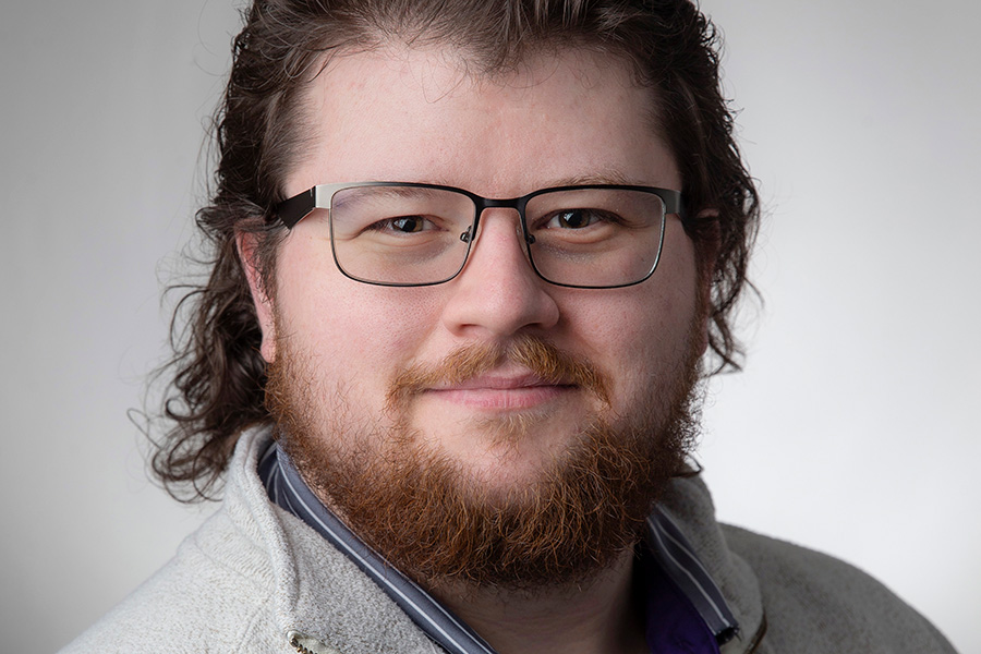 Aaron Nethery sitting in front of a grey background