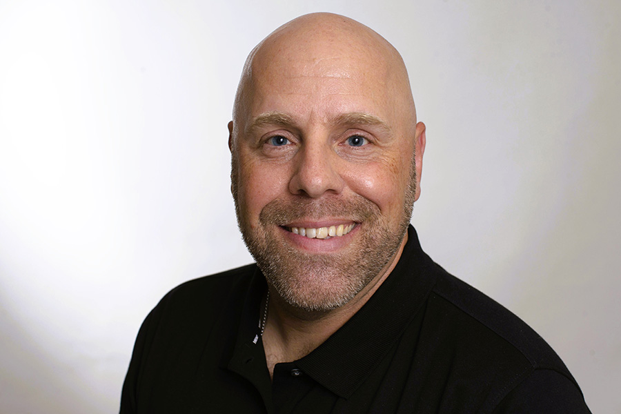 Nicholas Thompson in front of a white background wearing a black shirt.