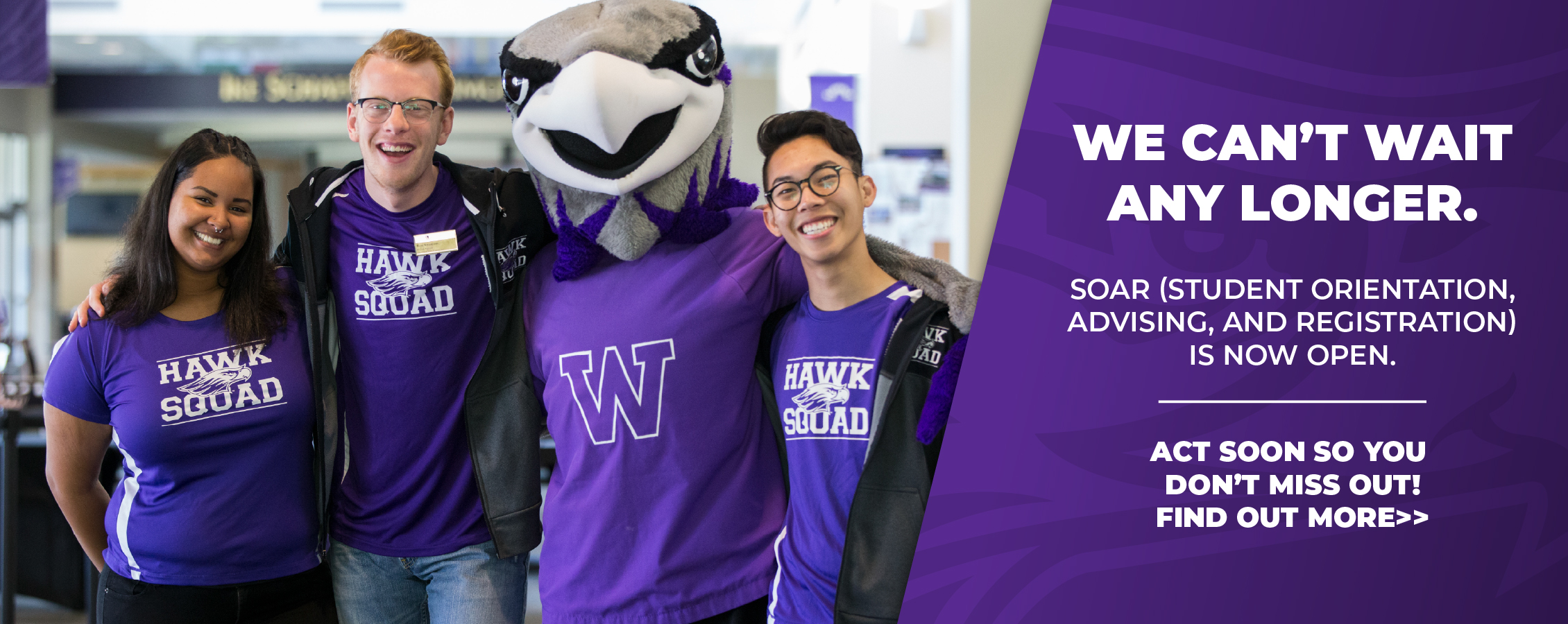 Three students stand with Willie and smile at the camera.