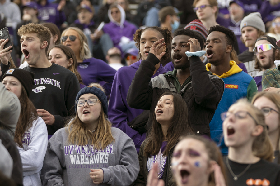 Students in the stands react during a football game.