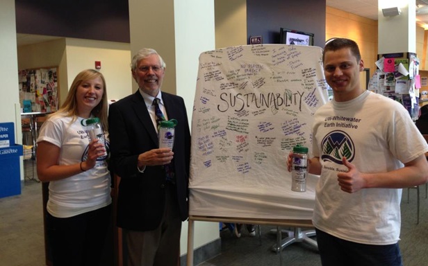 Three people standing in front of a presentation board