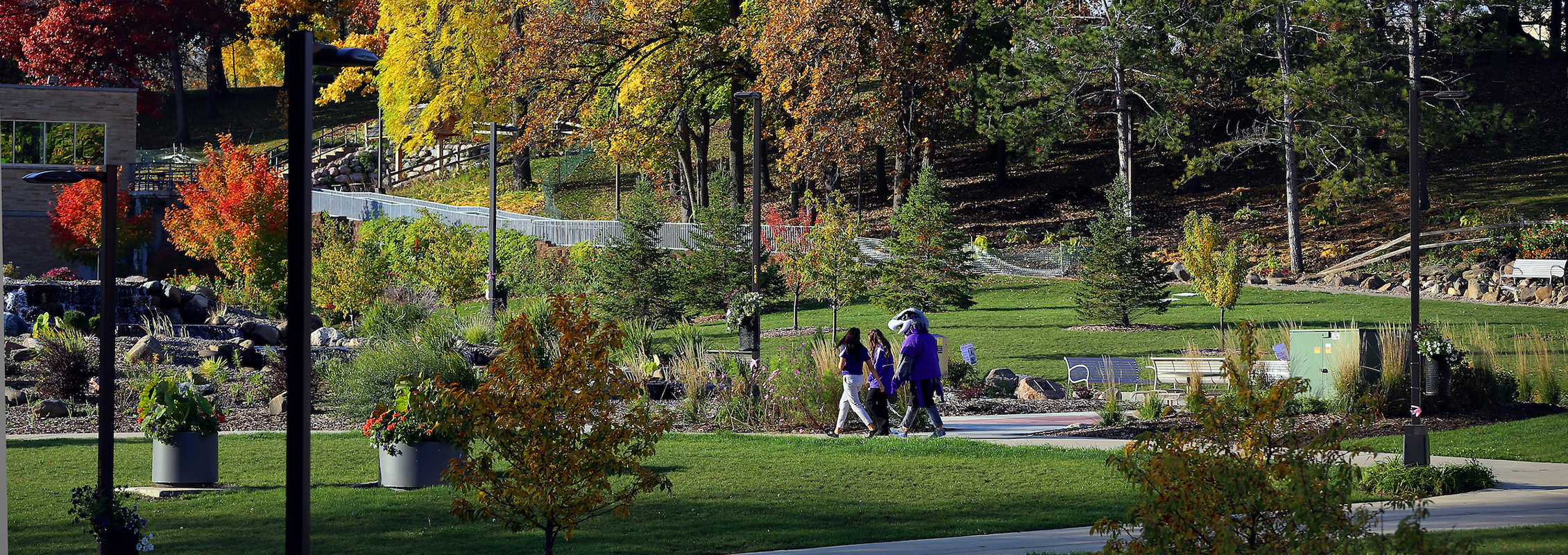 international students walking with Willie Warhawk