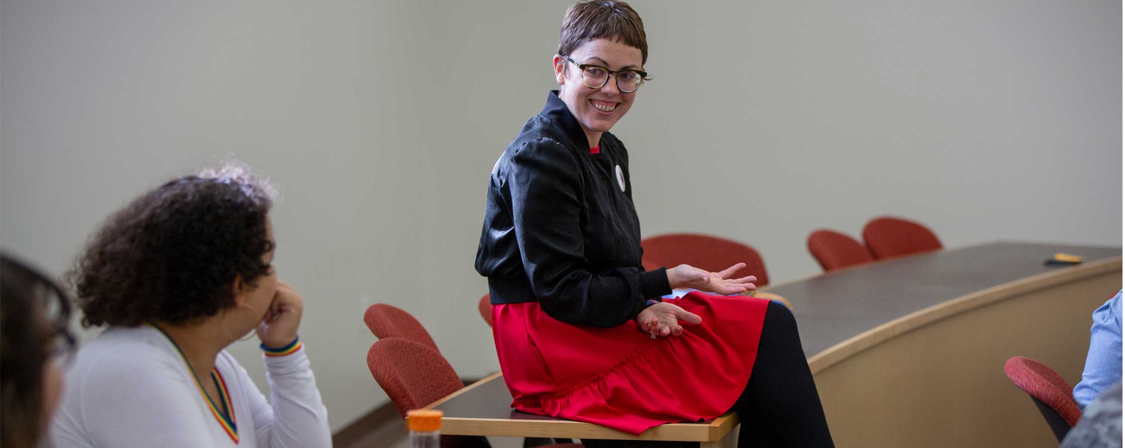 Stephanie Selvick sits on a table talking with students.