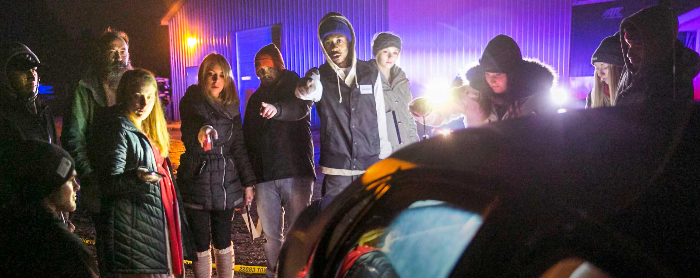 Students stand around a simulated crime scene.