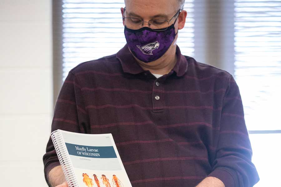 Tom Klubertanz holds an illustrated book on mayflies.