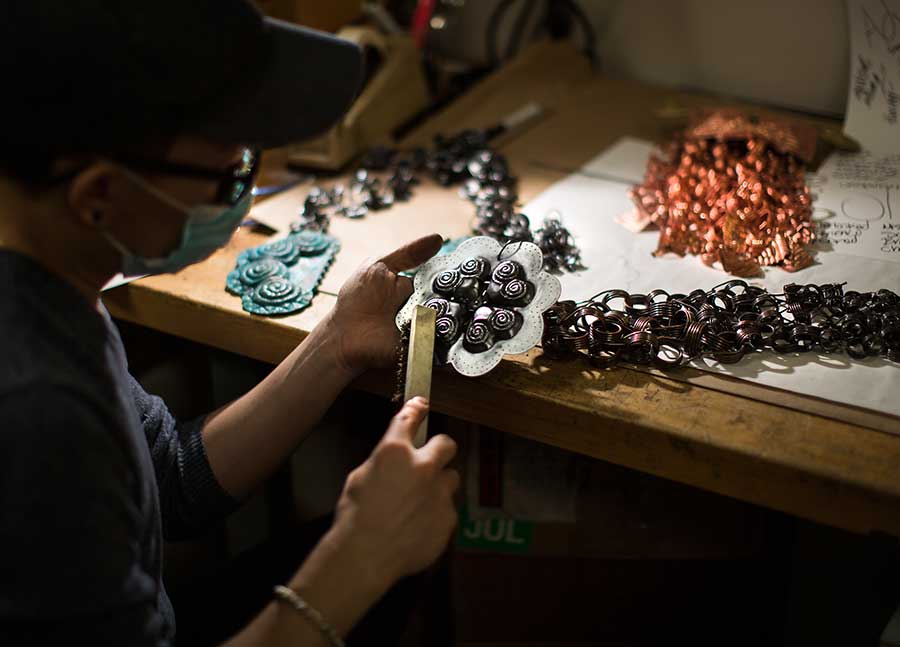 A student works on copper and brass pieces.