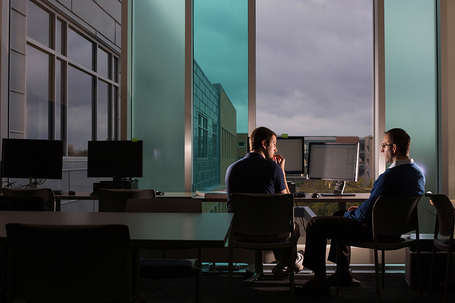 David Welsch talks with a student in Hyland Hall.