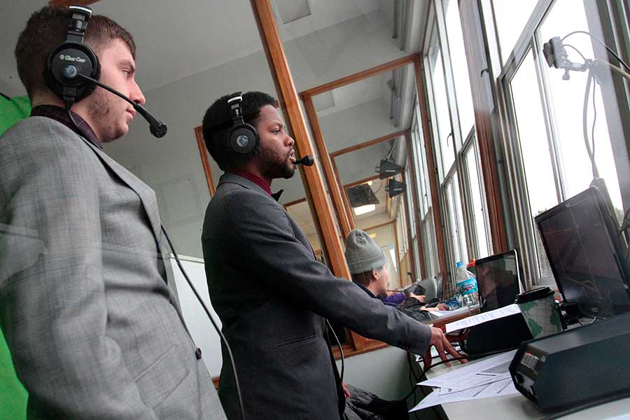 Two students broadcast a football game.