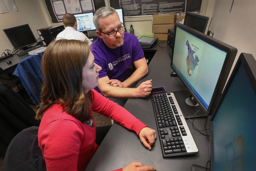 John Frye works with a student on a computer.