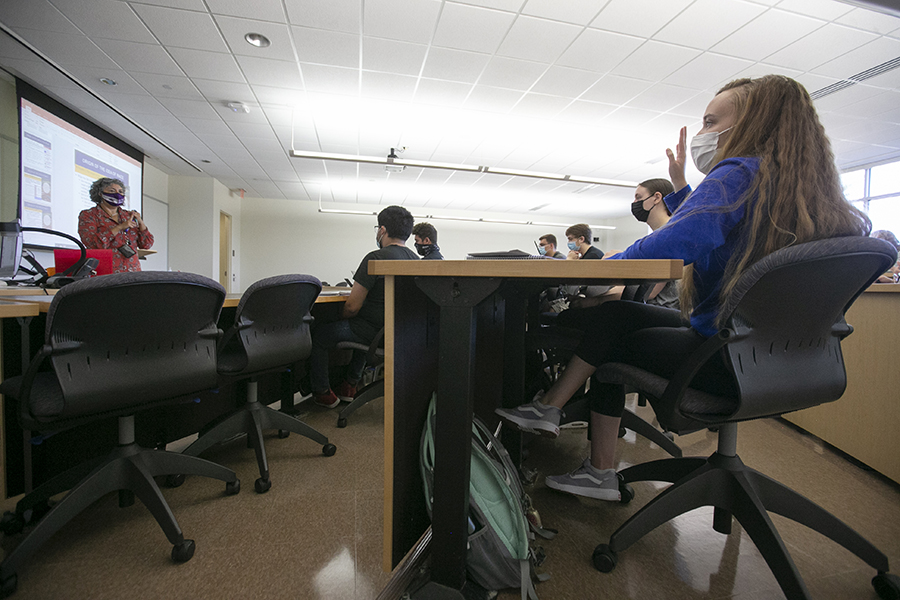 los estudiantes levantan las manos en un aula.