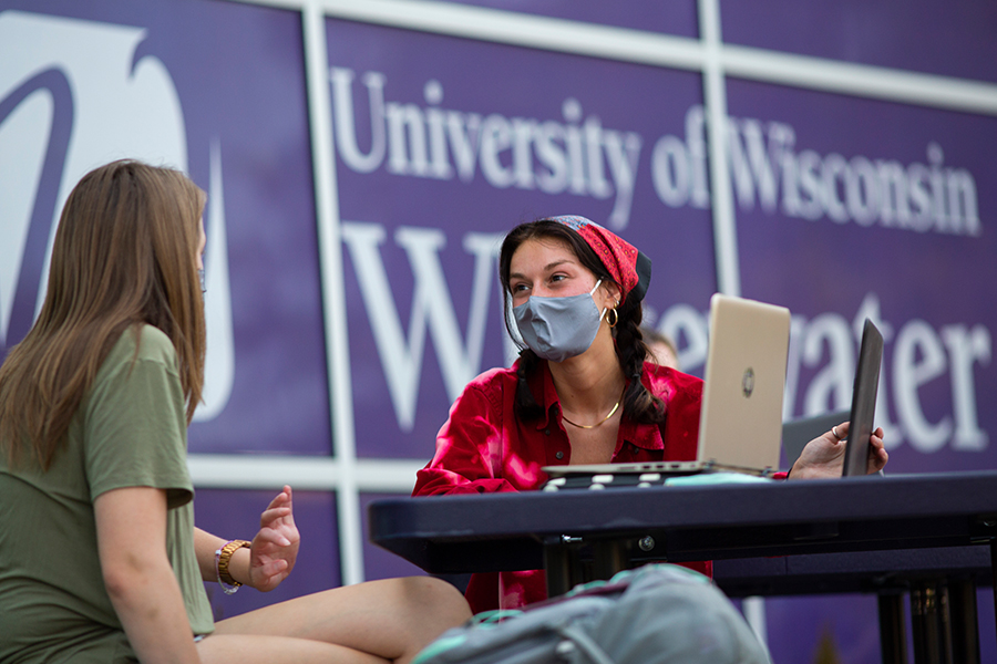 KTwo students talking at a table